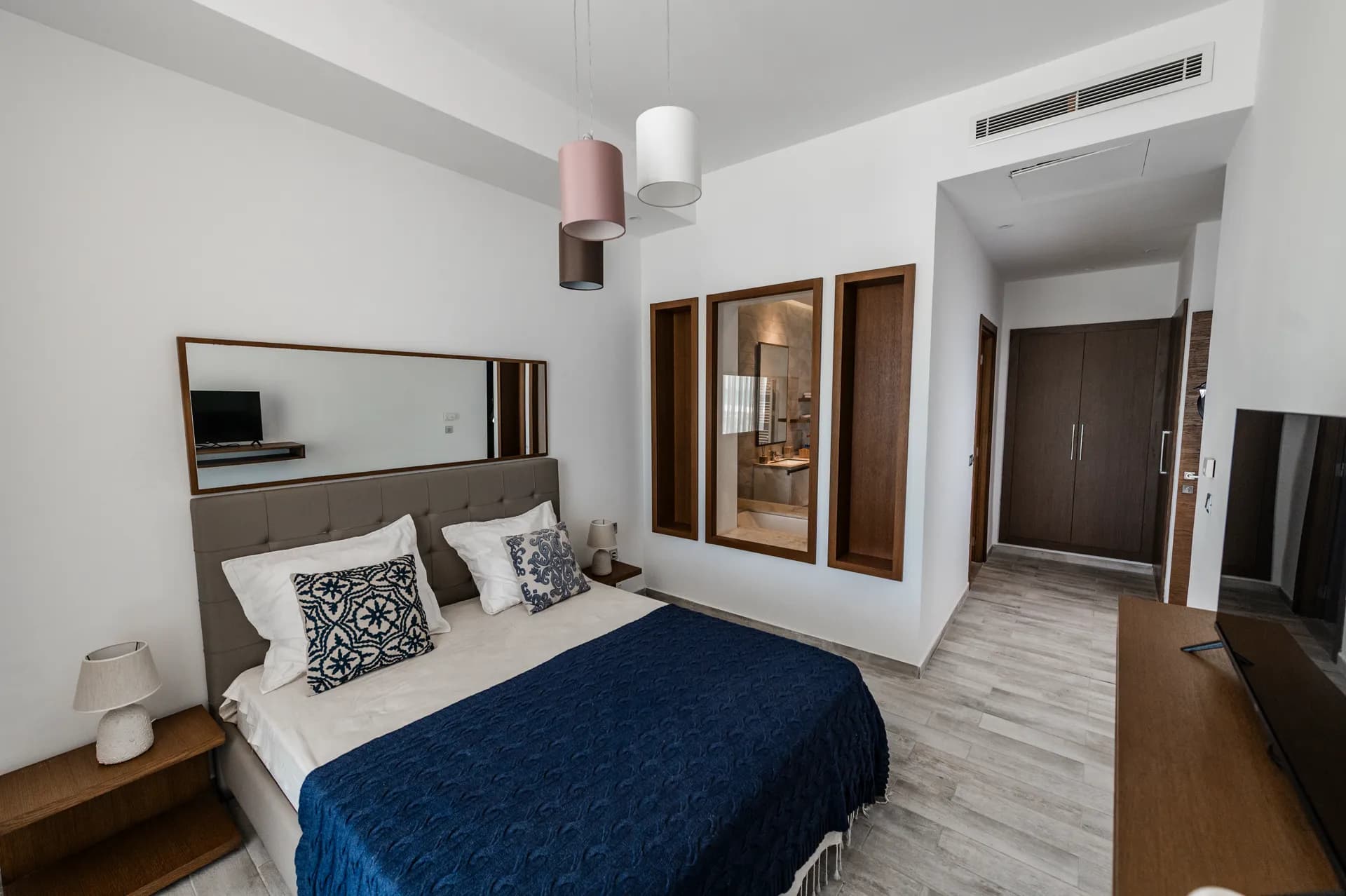 Chambre principale d'un appartement Nautilus avec lit double et jeté de lit bleu marine