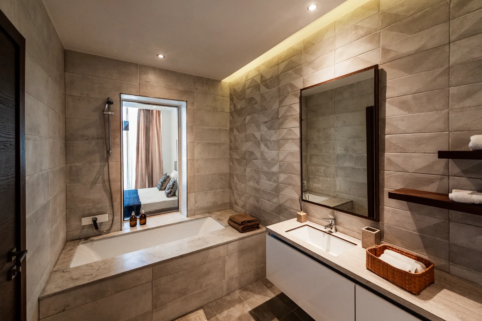 Salle de bains en pierre naturelle d'un appartement Nautilus avec baignoire et double vasque