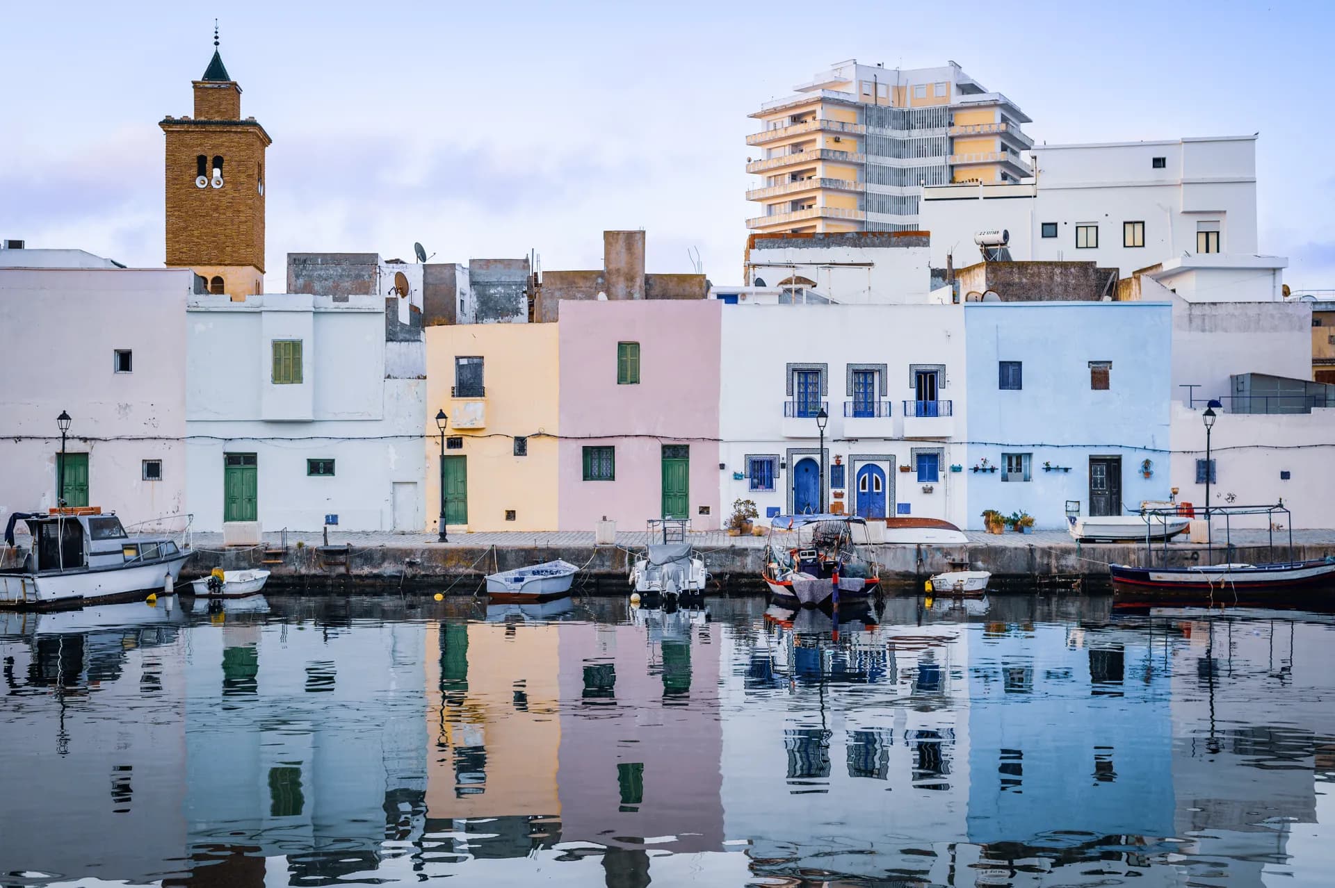 Façades pastel et minaret des maisons de pêcheurs sur les quais du vieux port de Bizerte