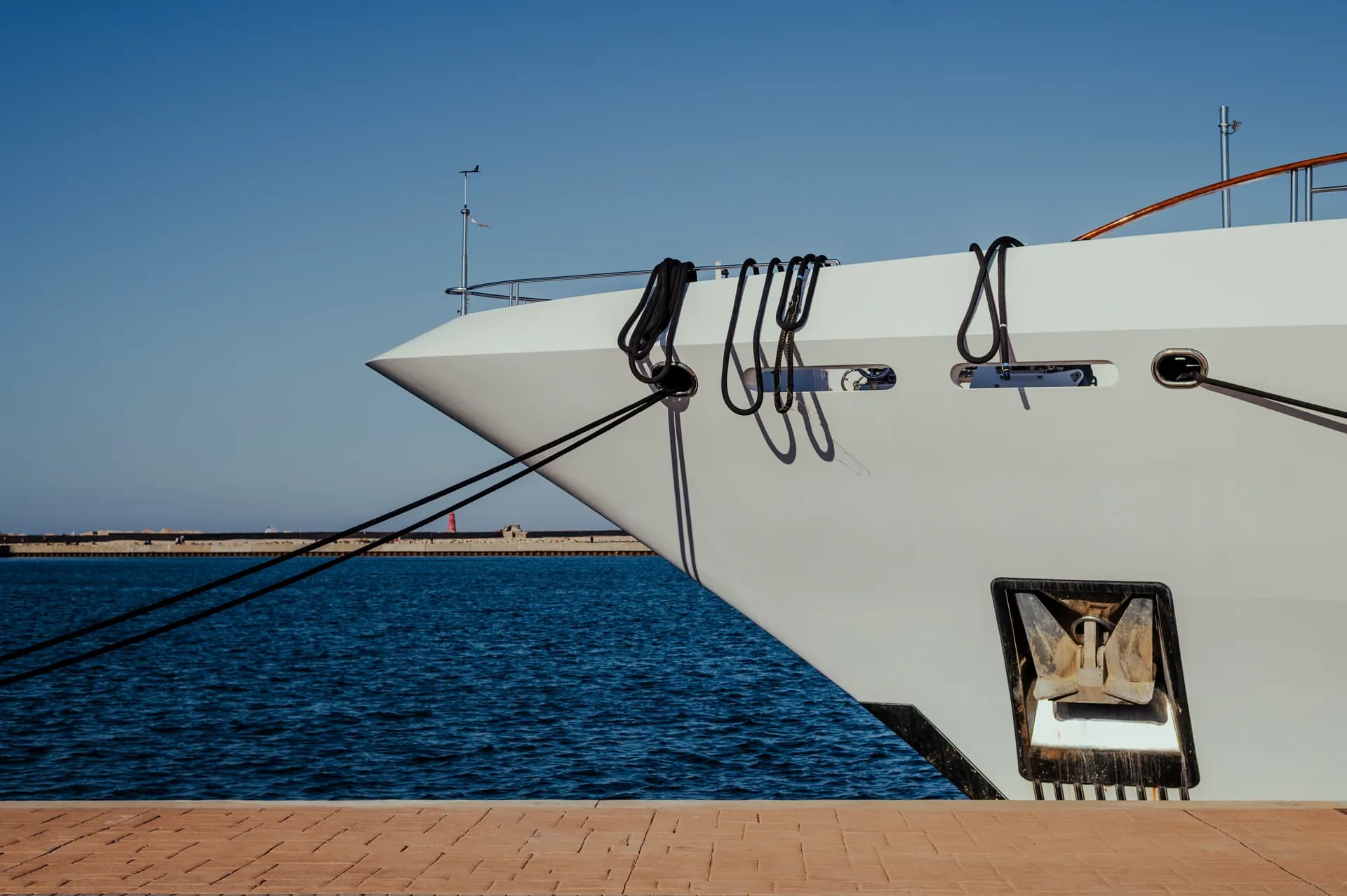Étrave d’un yacht amarré sur pendilles à Marina Bizerte, amarres capelées sur l’avant